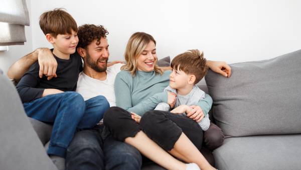 Family of four sitting on couch together