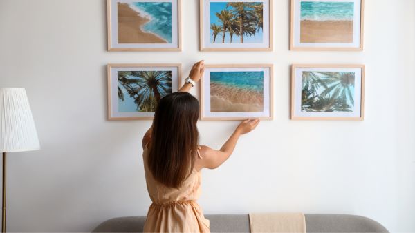 Woman hanging pictures on a wall